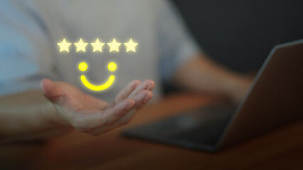Customer satisfaction concept with five star rating and smile face above hand, symbolizing positive feedback, quality service, online reviews, testimonial, and excellent user experience.