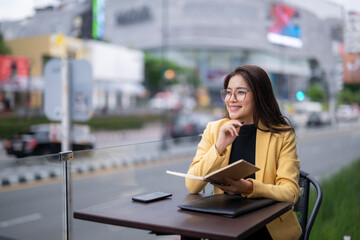 Businesswoman planning strategy while taking notes at outdoor cafe