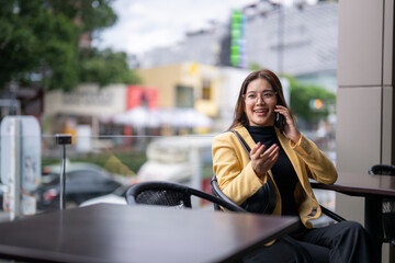 Businesswoman talking on phone at outdoor cafe in city