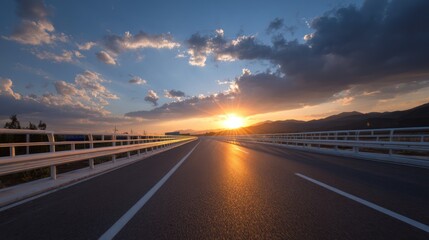 Obraz premium Open highway leading to sunset horizon with cloudy sky background