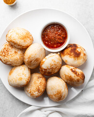 Overhead view of a plate of masa and pepper sauce, top view of food from northern nigeria masa rice cake and stew, nigerian ethnic foods