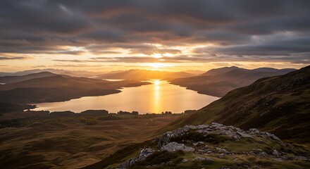 Scenic sunset over mountain lake landscape with dramatic clouds and golden light