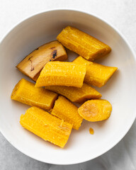 overhead view of Boiled ripe plantain in a white bowl, top view of nigerian cooked ripe plantain