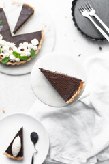 Overhead view of a slice of chocolate tart on a white plate, top view of no bake chocolate tart on a white background, a slice of chocolate pie