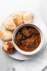 Overhead view of a plate of masa and miyan taushe, top view of food from northern nigeria masa and taushe, nigerian ethnic foods