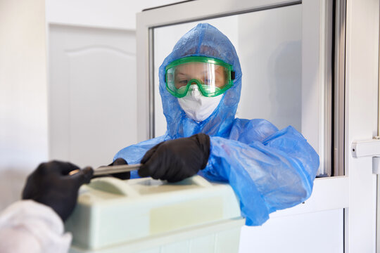 Scientist passing container with blood samles to a nurse in laboratory. Cooling box for medical samples transportation. Medical research concept