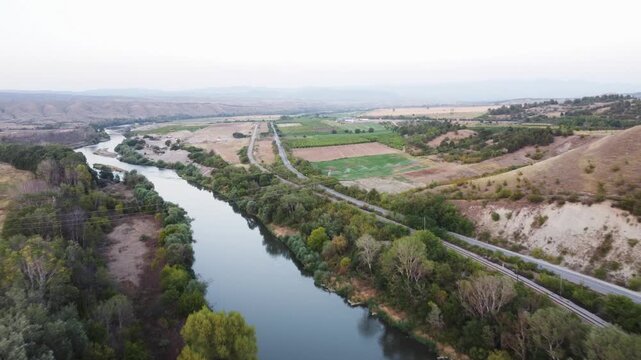 Aerial View of the Vardar River, Road, and Railway in North Macedonia's Lush Green Countryside
