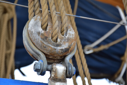 Wooden triple deadeye for sailing ship with lanyard.