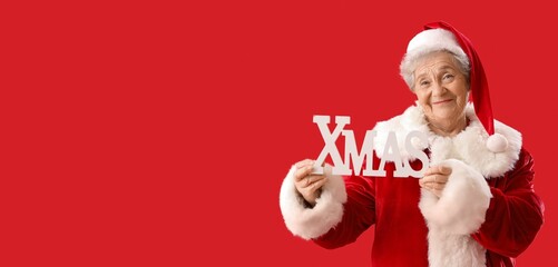Senior woman dressed as Santa Claus with word XMAS on red background with space for text