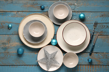 Beautiful table setting with Christmas decorations on blue wooden background