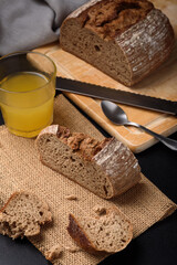 Dark rye sourdough bread sliced on black background
