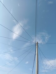 Electric pole connect with wires with blue sky as background
