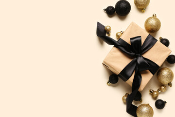 Gift box and Christmas balls on beige background
