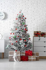 Stylish interior of living room with beautiful Christmas tree and gifts