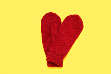 Stylish warm mittens on yellow background