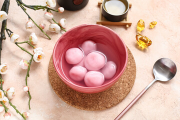 Bowl of tangyuan, Chinese decor and sakura on beige background. Dongzhi Festival