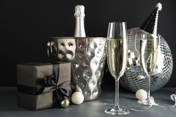 Glasses of champagne, Christmas gift and decor on dark background