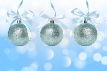 Beautiful blue glittery ornaments are adorned with white ribbons