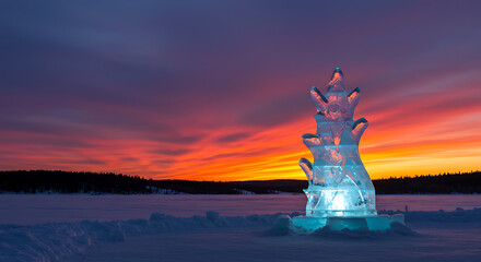 Ice Sculpture Amidst Sunset: An intricately carved ice sculpture stands against a breathtaking sunset, the icy artistry shimmering under a fiery sky.