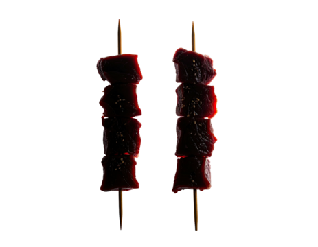 Two skewers, each loaded with reddish-brown, cubed food, isolated against black