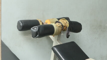 The athletes' gym equipment at the recovery center is worn out with age. This equipment can be used for physical recovery and muscle fitness through sit-ups.