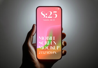 Hand holding a smartphone with a glowing screen in a dark environment for a mockup