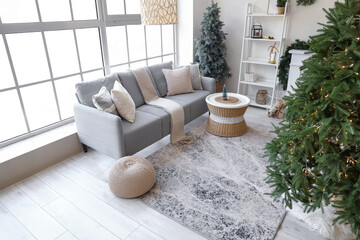 Interior of living room with grey sofa, Christmas tree and festive decorations
