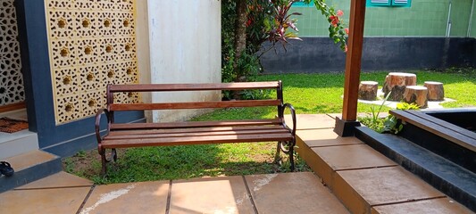 A rustic wooden bench in a peaceful sunlit garden patio