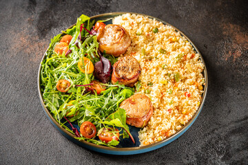 Pork medallions with couscous and fresh salad top view