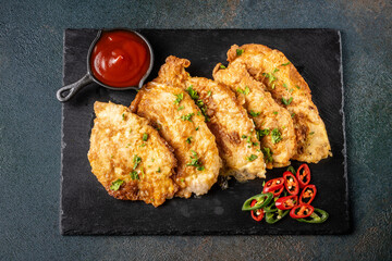 Fried schnitzel with egg batter, chili and ketchup