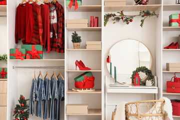 Modern wardrobe with stylish Christmas clothes and gift boxes