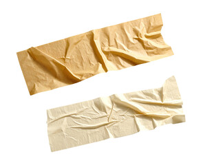 Two pieces of crumpled masking tape with visible adhesive on black background