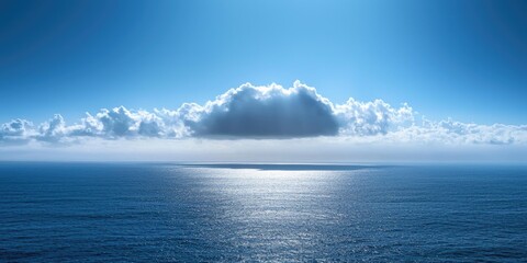 Obraz premium A vast, open ocean with a single, large, white cloud floating above it, casting a soft, diffused light on the water below.