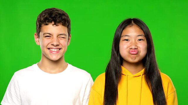 Playful Teenage Couple Making Funny Faces on Green Screen.