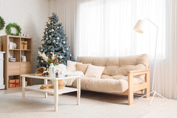 Interior of living room with Christmas tree, sofa and table