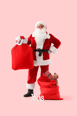 Santa Claus with bags, Christmas gifts and word XMAS on pink background