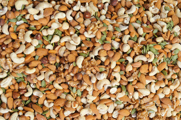 Diverse mix of nuts and seeds on a wooden surface