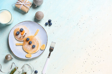 Plate with pancakes in shape of snowman on light background. Christmas celebration
