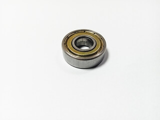 one bicycle bearing, one motorcycle bearing, metal bearing isolated on white background, machine part component, as industrial machine mechanical technology design, space for tek.