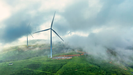 Aerial view of Wind turbines amidst misty landscape at sunset in Da lat, Vietnam