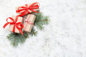 Christmas gift boxes with fir tree branches on white grunge background