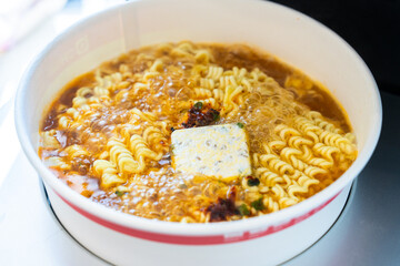 Boiling Korean ramen with spicy sauce powder and egg