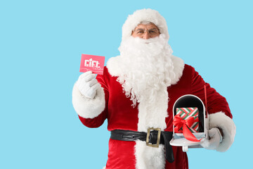 Santa Claus with gift card and mailbox on blue background. Christmas celebration