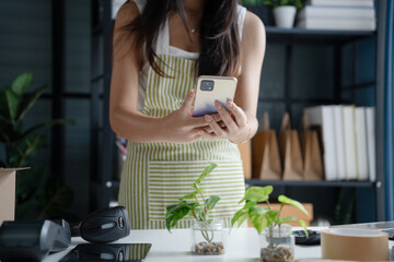 Asian Women Entrepreneurs in SME Using Laptops to Process Online Orders and Manage Parcel Deliveries.