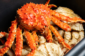 Large red freshly cooked king crab with spiny textured shell and extended legs, showcasing natural coloration and form, widely recognized as valuable seafood species