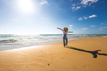 Woman on the beach. Happy young woman in a white shirt enjoying her vacation on the beach.
