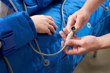 woman receiving the procedure of pressure therapy to make her legs perfect, without varicose vein, and edema