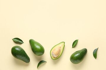 Fresh ripe avocados and leaves on yellow background