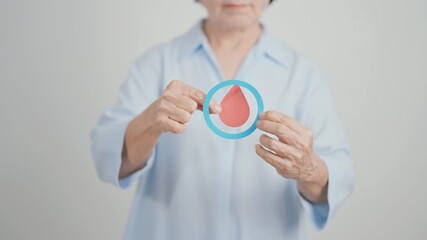 Elderly woman with Blue Circle and red Blood drop for World Diabetes Day, Blue November Health month, Diabetes awareness, Blood sugar check, Insulin, Glucose screening, donation and Health checkup