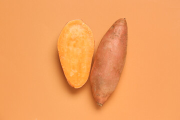 Fresh sweet potatoes on orange background